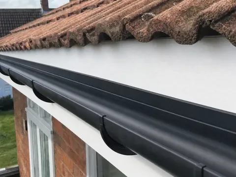 The same gutter cleared and flowing after cleaning
